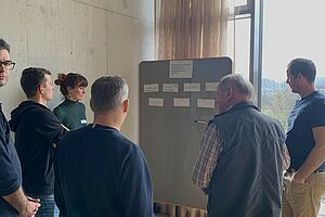 FiBL_FlorineStäuble Eine Gruppe Personen steht vor einem Flipchart und diskutiert.